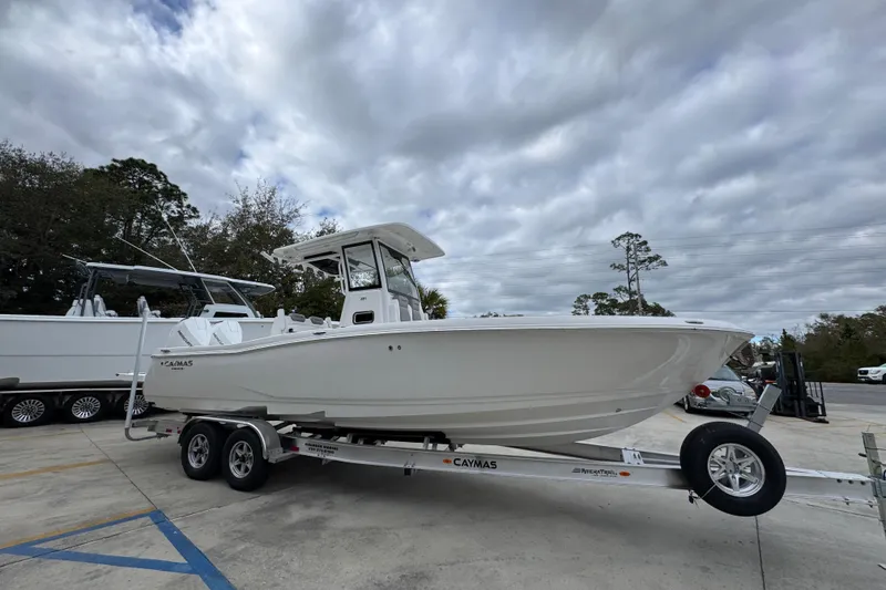 Slide: The Image of 2026 Caymas 291 boat on trailer, parked outdoors under cloudy sky. - 18