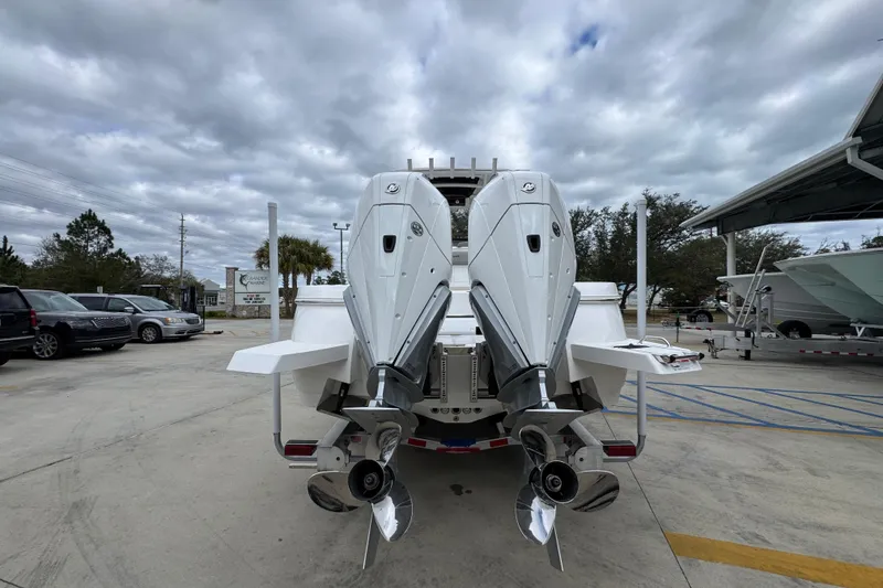 Slide: The Image of 2026 Caymas 291 boat with dual outboard engines, parked under cloudy skies. - 22