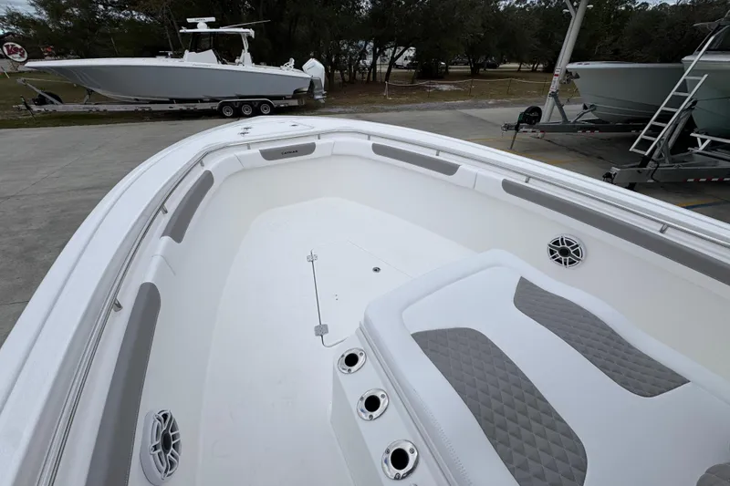 Slide: The Image of 2026 Caymas 291 boat interior with cushioned seating and speakers, parked on a trailer. - 27