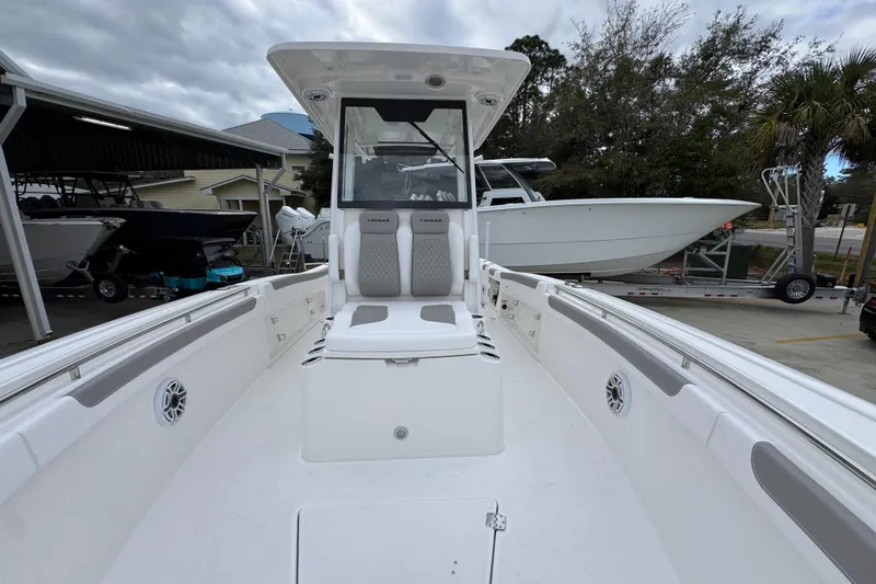 Slide: The Image of 2026 Caymas 291 boat interior with seating and console, docked outdoors. - 30