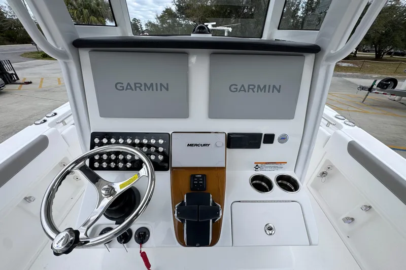Slide: The Image of 2026 Caymas 291 boat dashboard with dual Garmin displays and Mercury controls. - 38