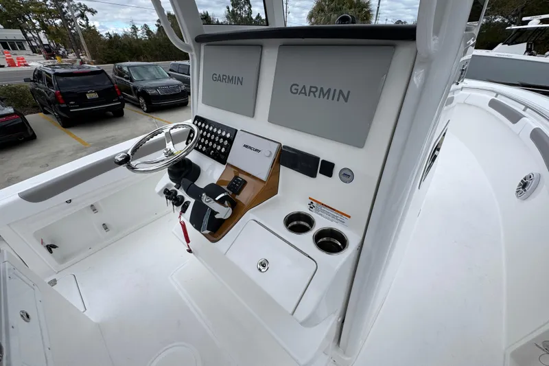 Slide: The Image of 2026 Caymas 291 boat dashboard with Garmin displays and Mercury controls. - 39