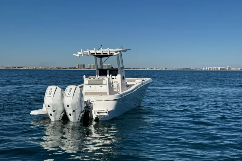 Slide: The Image of 2026 Caymas 291 boat with dual engines on open water, clear sky background. - 5