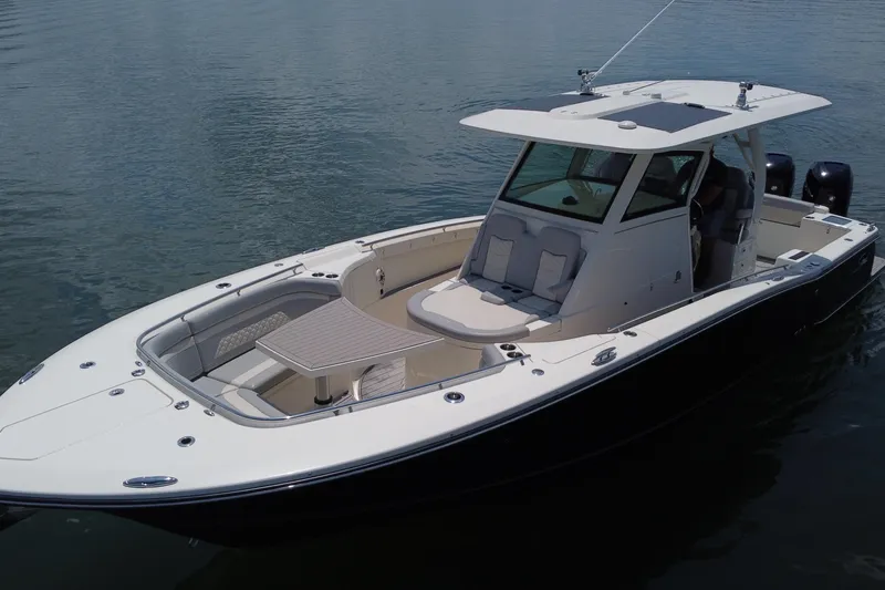 Slide: The Image of 2021 Scout 330 LXF boat on calm water, featuring sleek design and spacious deck. - 5
