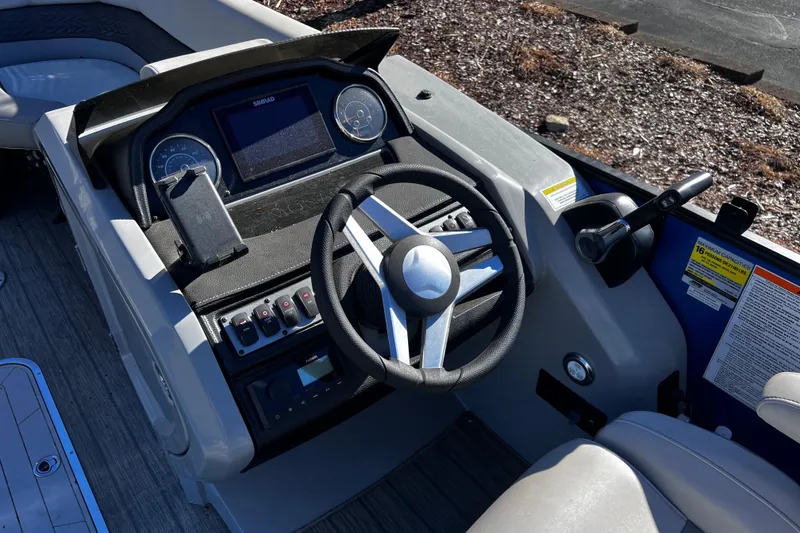 Slide: The Image of 2022 Godfrey Monaco 235 SFL boat dashboard with steering wheel and controls. - 14