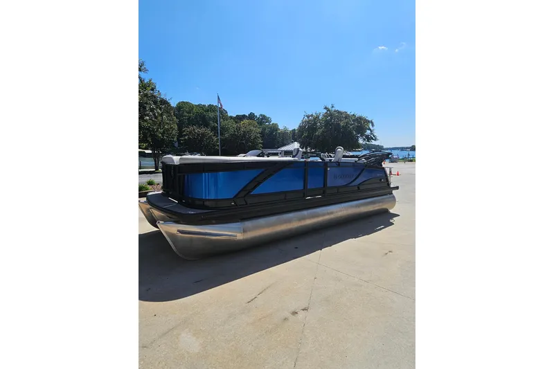 Slide: The Image of 2022 Godfrey Monaco 235 SFL pontoon boat in blue, parked on concrete. - 3