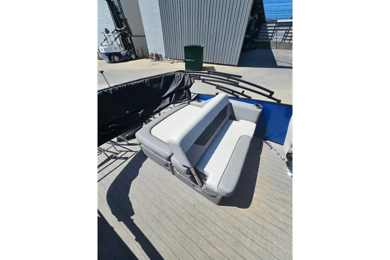 Slide: The Image of 2022 Godfrey Monaco 235 SFL pontoon boat, blue and black, parked outside a warehouse. - 6