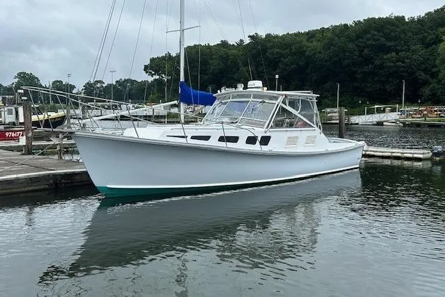 The Image of 1978 Dyer 40 Express Cruiser docked in a marina, surrounded by calm water. - 0
