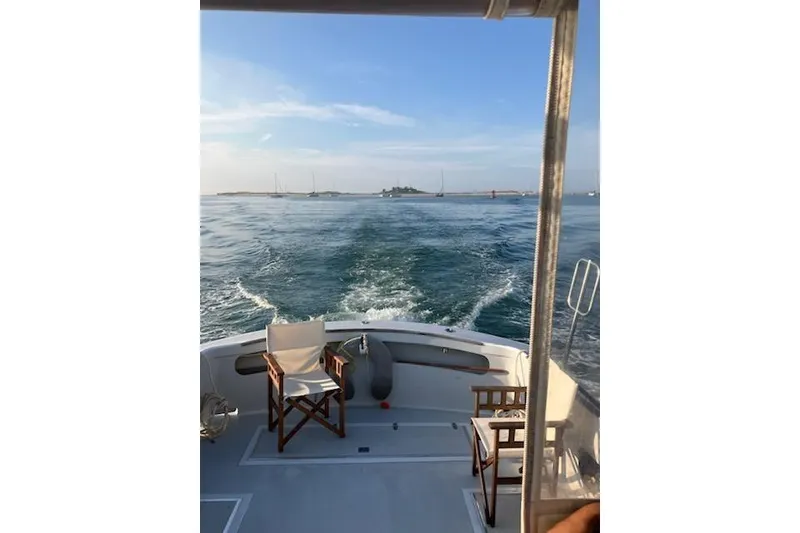 Slide: The Image of 1978 Dyer 40 Express Cruiser on open water, featuring deck chairs and ocean view. - 16