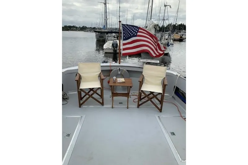 Slide: The Image of 1978 Dyer 40 Custom Express Cruiser with chairs and American flag at marina. - 17
