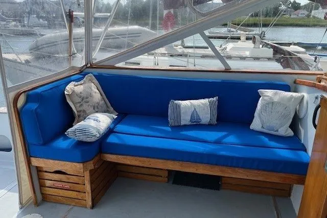 Slide: The Image of 1978 Dyer 40 Custom Express Cruiser with blue cushioned seating and nautical-themed pillows. - 18