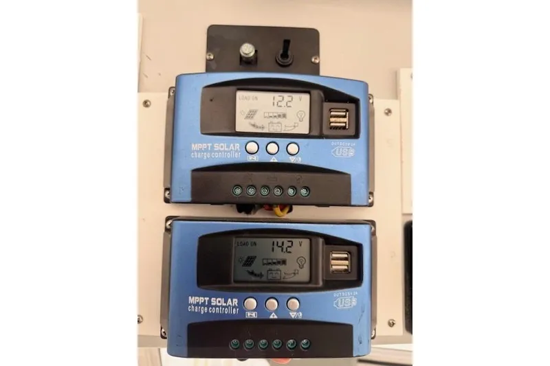 Slide: The Image of MPPT solar charge controllers on 1978 Dyer 40 Custom Express Cruiser, displaying voltage readings. - 27