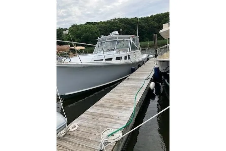 Slide: The Image of 1978 Dyer 40 Express Cruiser docked at a marina with lush greenery. - 3