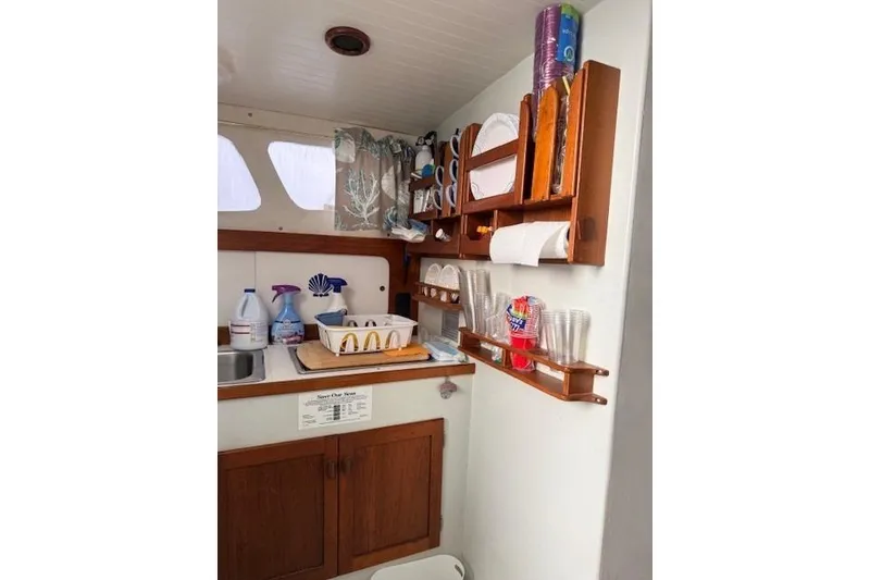 Slide: The Image of 1978 Dyer 40 Custom Express Cruiser kitchen with wooden cabinets and organized shelves. - 41