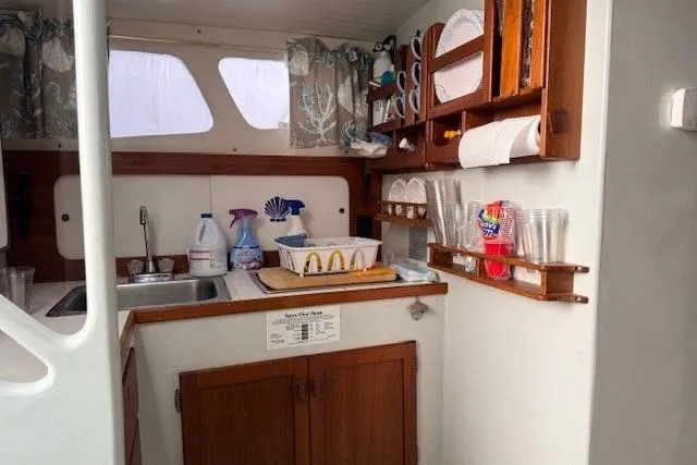 Slide: The Image of 1978 Dyer 40 Custom Express Cruiser kitchen with wooden cabinets and essential supplies. - 42