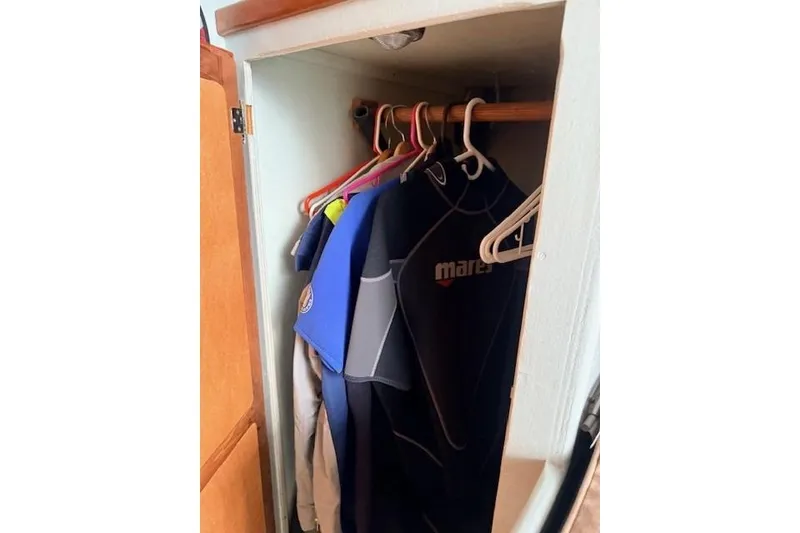 Slide: The Image of Closet on 1978 Dyer 40 Custom Express Cruiser with wetsuits hanging inside. - 56