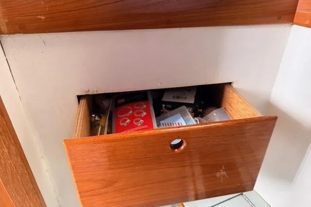 Slide: The Image of Open wooden drawer on 1978 Dyer 40 Custom Express Cruiser, containing various items. - 59