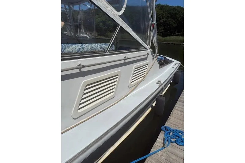 Slide: The Image of 1978 Dyer 40 Express Cruiser docked, showcasing side view and protective fenders. - 6