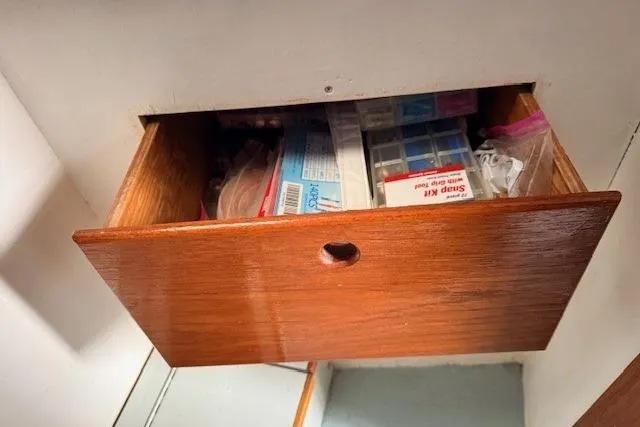 Slide: The Image of Open wooden drawer on 1978 Dyer 40 Custom Express Cruiser, containing various items. - 60