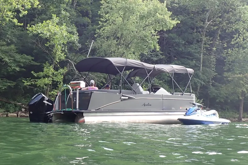 The Image of 2021 Avalon 2585 Catalina EL pontoon boat on a scenic lake with trees. - 1