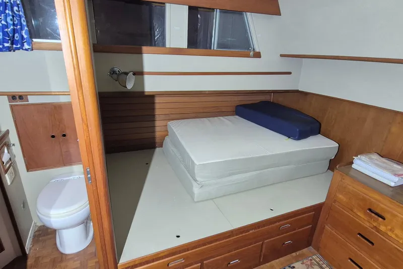 Slide: The Image of 1985 Grand Banks 42 Classic cabin interior with bed, wooden cabinetry, and toilet. - 10