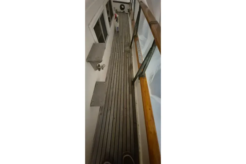 Slide: The Image of Narrow deck view of 1985 Grand Banks 42 Classic yacht with wooden railings. - 102