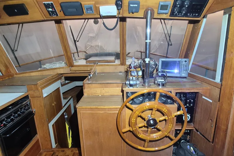 Slide: The Image of 1985 Grand Banks 42 Classic helm with wooden wheel and navigation equipment. - 103