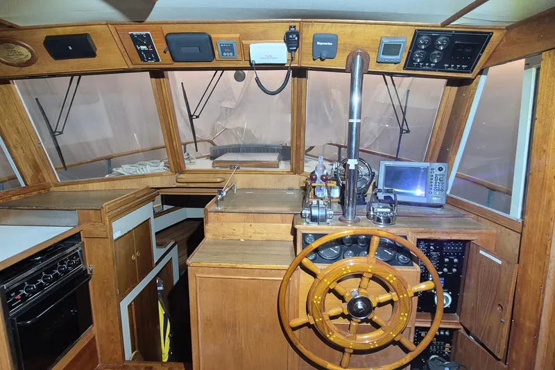 Slide: The Image of 1985 Grand Banks 42 Classic helm with wooden wheel and navigation equipment. - 104
