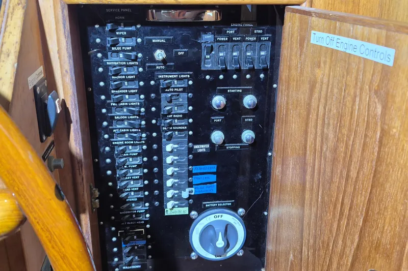 Slide: The Image of Control panel of a 1985 Grand Banks 42 Classic boat with various switches and dials. - 105