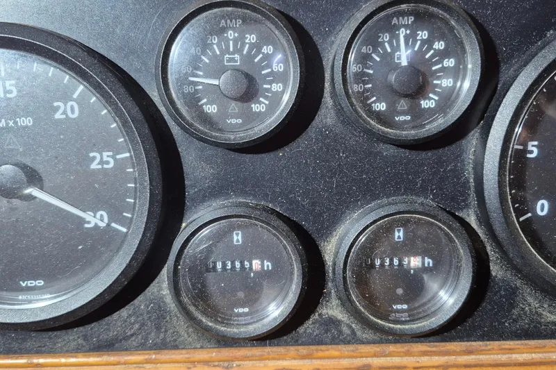 Slide: The Image of Dashboard gauges of a 1985 Grand Banks 42 Classic boat, showing amp and hour meters. - 110