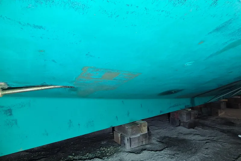 Slide: The Image of Underside of 1985 Grand Banks 42 Classic boat on blocks, showing hull details. - 113