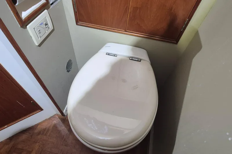 Slide: The Image of Toilet in 1985 Grand Banks 42 Classic yacht bathroom with wooden cabinetry. - 15