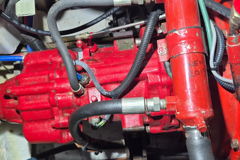 Slide: The Image of Engine compartment of a 1985 Grand Banks 42 Classic, featuring red mechanical components. - 36
