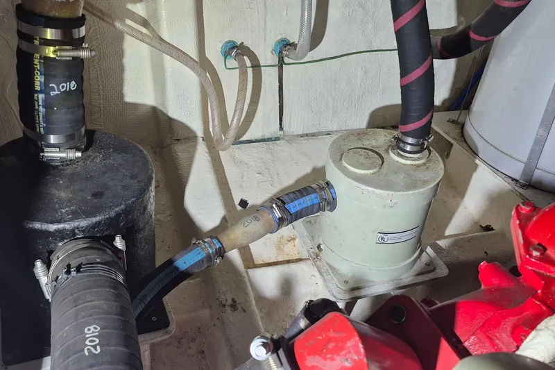 Slide: The Image of Engine room of 1985 Grand Banks 42 Classic with hoses and mechanical components. - 37