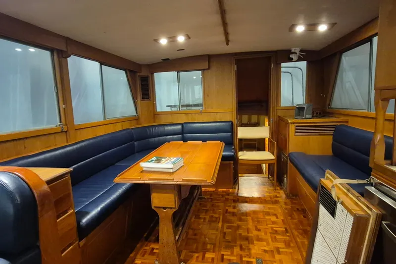 Slide: The Image of Interior of 1985 Grand Banks 42 Classic yacht with wood paneling and blue seating. - 4
