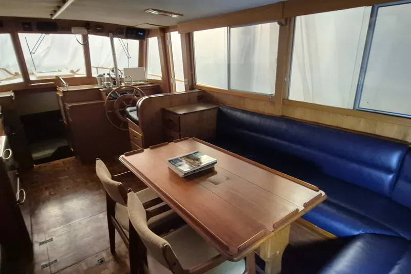 Slide: The Image of Interior of 1985 Grand Banks 42 Classic yacht with wooden furnishings and blue seating. - 5
