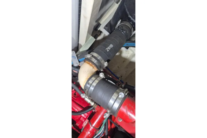 Slide: The Image of Engine compartment of a 1985 Grand Banks 42 Classic boat, showing hoses and clamps. - 56