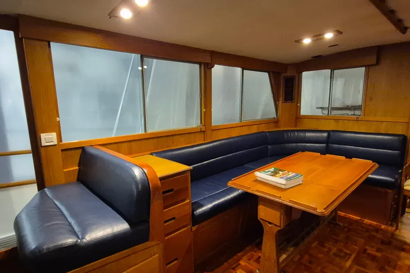 Slide: The Image of Interior of 1985 Grand Banks 42 Classic yacht with blue seating and wooden table. - 6