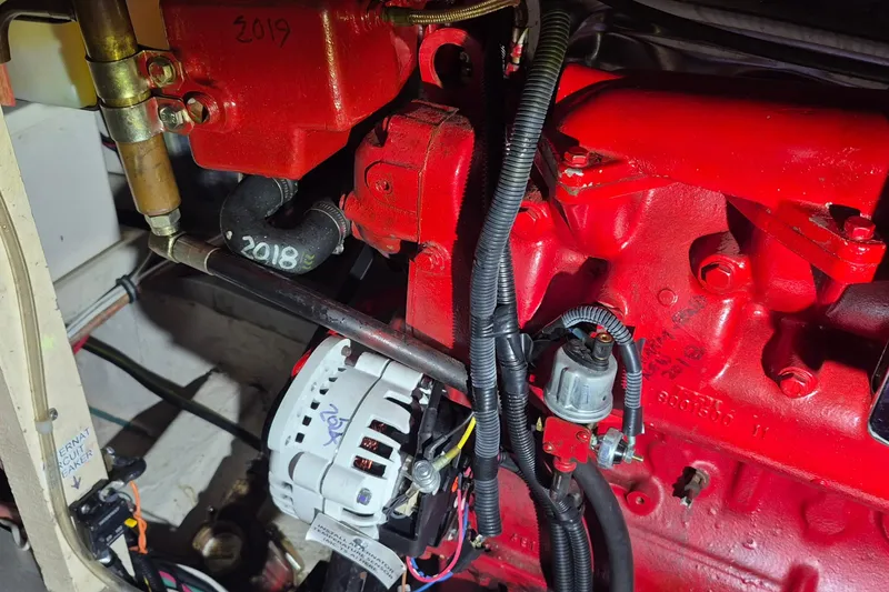 Slide: The Image of Engine compartment of a 1985 Grand Banks 42 Classic boat, featuring red components and wiring. - 60