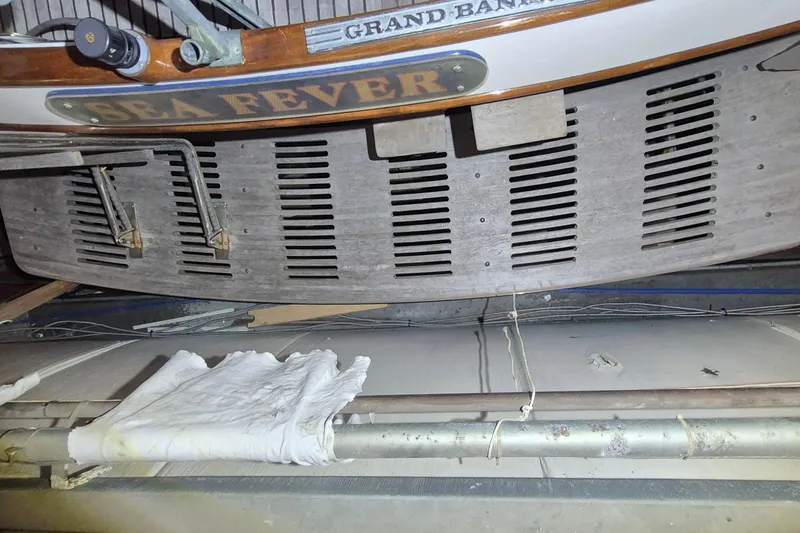 Slide: The Image of 1985 Grand Banks 42 Classic boat named "Sea Fever" in storage, showing stern details. - 65
