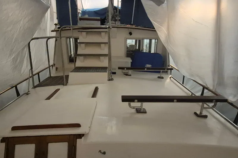 Slide: The Image of 1985 Grand Banks 42 Classic yacht deck under cover, showcasing stairs and railings. - 69