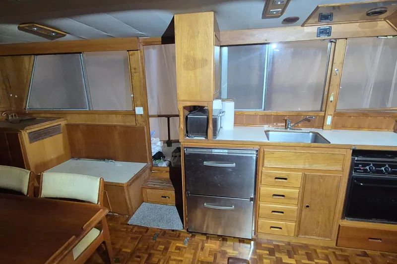 Slide: The Image of 1985 Grand Banks 42 Classic yacht interior with wooden cabinetry and kitchen amenities. - 7