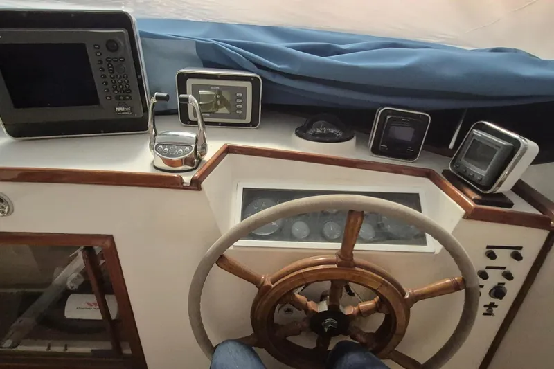 Slide: The Image of Helm of 1985 Grand Banks 42 Classic with navigation instruments and wooden steering wheel. - 70