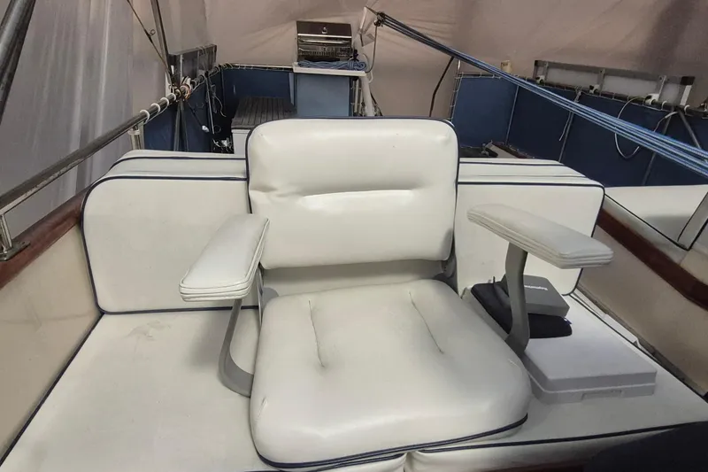Slide: The Image of Captain's chair on 1985 Grand Banks 42 Classic yacht, featuring white upholstery and armrests. - 75