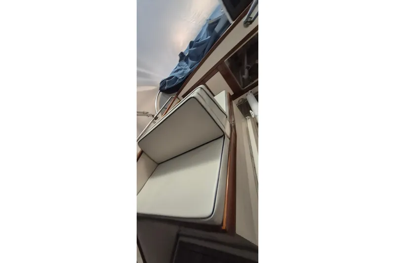 Slide: The Image of 1985 Grand Banks 42 Classic interior with white cushioned seating and wooden accents. - 80