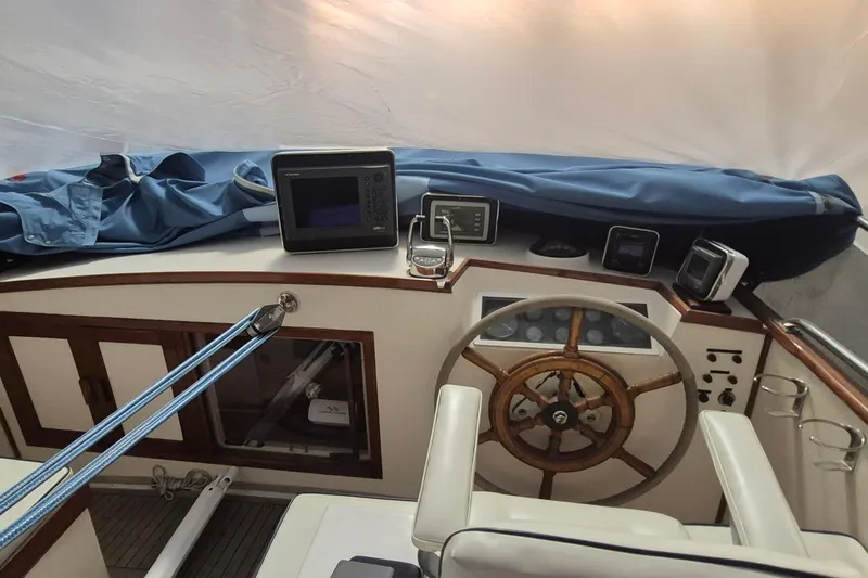 Slide: The Image of 1985 Grand Banks 42 Classic helm with wooden wheel and navigation equipment. - 83