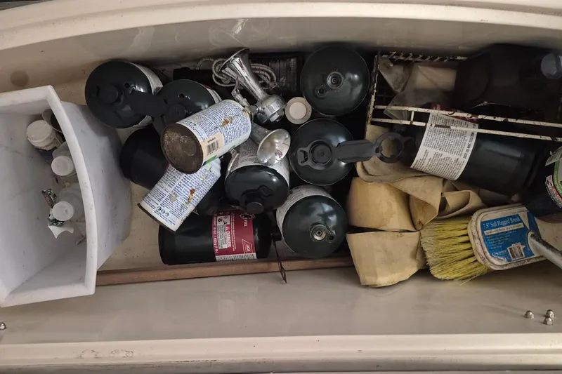 Slide: The Image of Storage compartment on 1985 Grand Banks 42 Classic with propane canisters and cleaning supplies. - 88