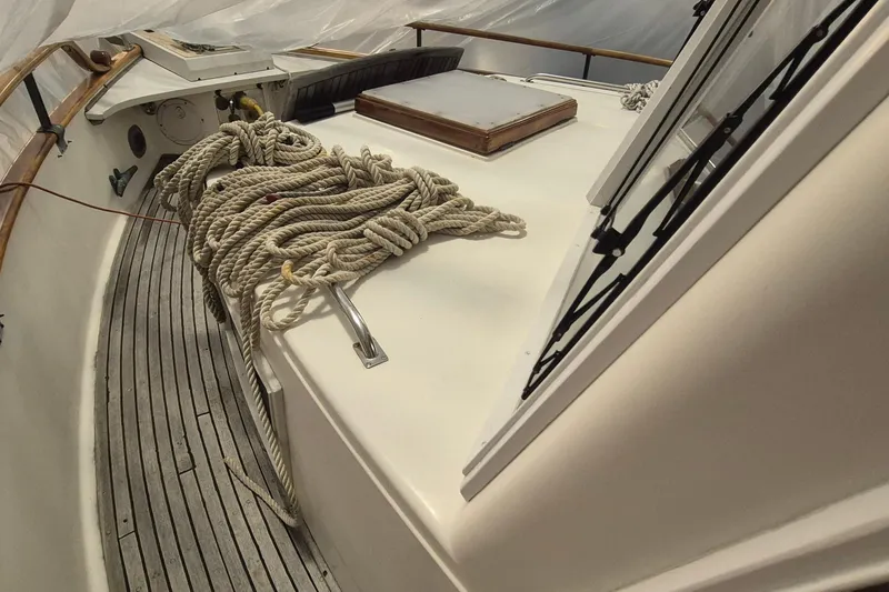 Slide: The Image of 1985 Grand Banks 42 Classic yacht deck with coiled ropes and wooden railings. - 91