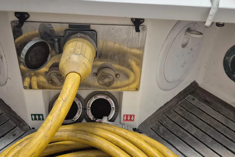 Slide: The Image of Yellow power cable on 1985 Grand Banks 42 Classic boat deck, near utility connections. - 96