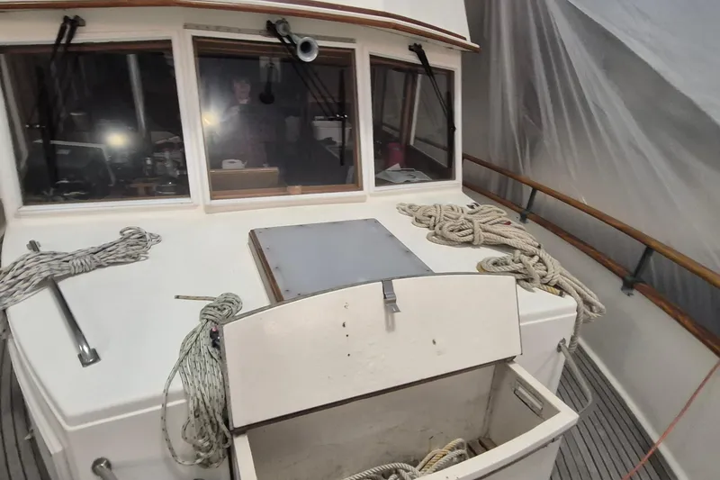 Slide: The Image of 1985 Grand Banks 42 Classic yacht deck with ropes and storage compartment. - 98